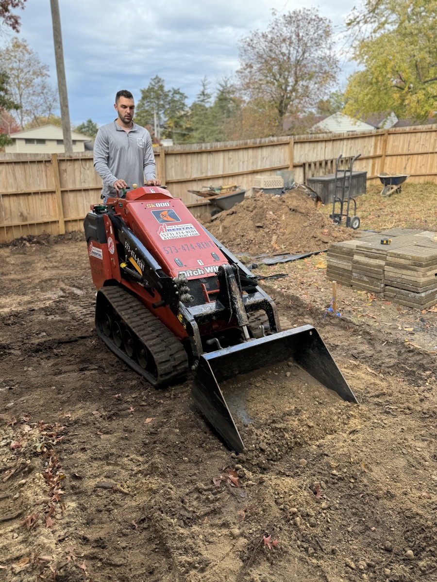Atlas Excavation operator on skid steer during backyard excavation project