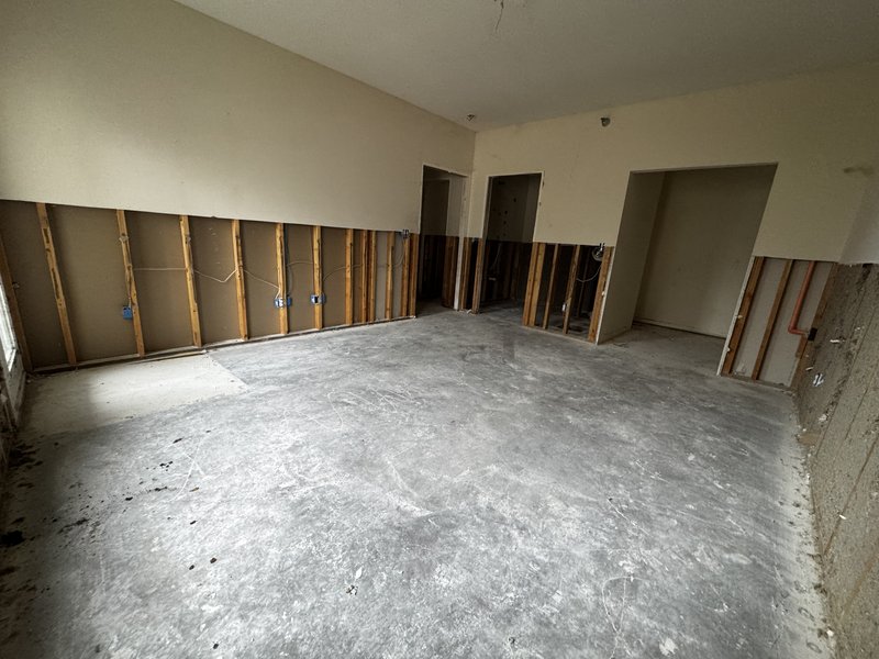 Completed commercial strip out demolition in Mid-Missouri showing an open white box space with bare slab and framing ready for tenant buildout