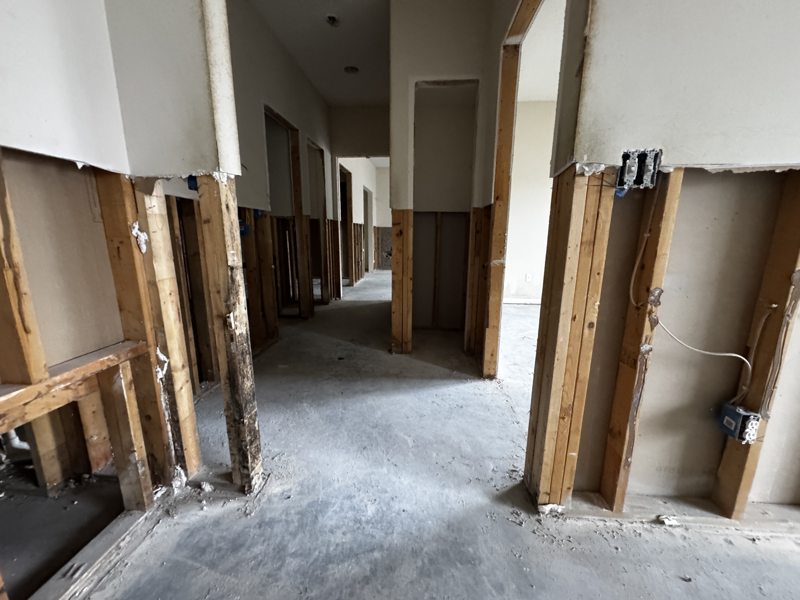 Interior partial demolition in Mid-Missouri with drywall stripped to the studs, wiring exposed, and flooring removed down to the slab