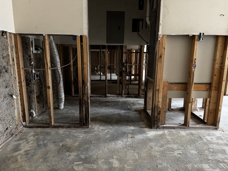 Tenant finish demolition in Mid-Missouri with wall framing exposed and HVAC ducting, electrical panel, and plumbing left in place for the new buildout