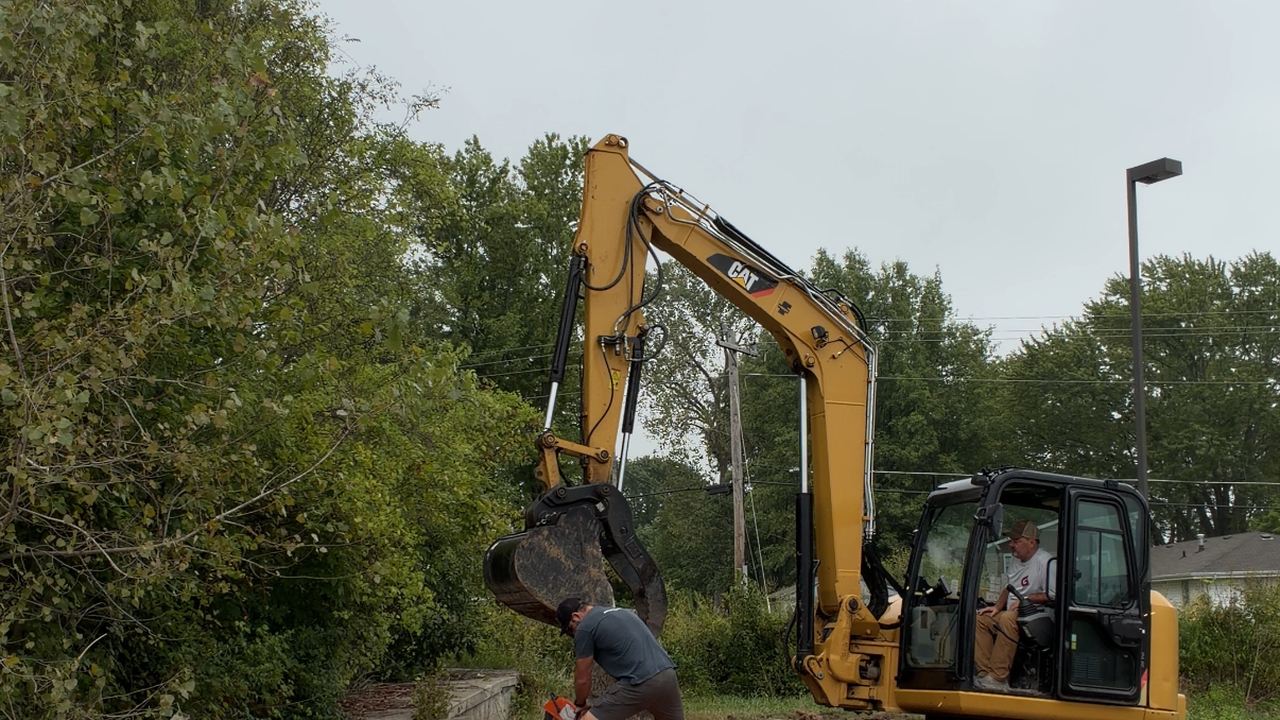 Excavator grading a lot base before paving
