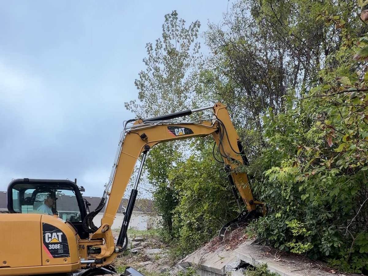 Cat 308 excavator breaking out a concrete retaining wall in Columbia, MO