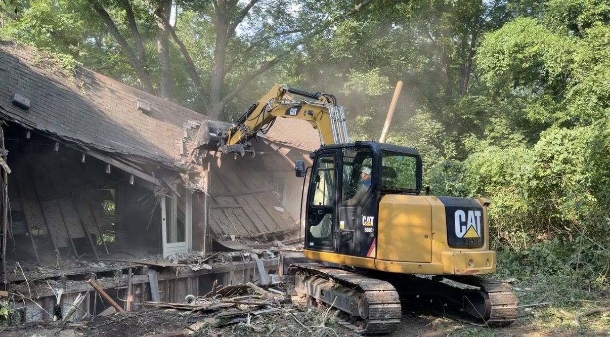 Cat 308 excavator tearing the roof off a house during a demolition in Columbia, MO